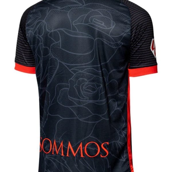 Back view of a navy athletic jersey with a subtle rose pattern, red collar, and red sleeve cuffs.