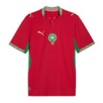 Red soccer jersey with green side panels, gold Puma logos, and a circular team crest on the chest (front view).