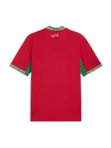 Back view of a red Moroccan-style tunic with green side panels and decorative patterned trim at cuffs and collar; Arabic script on upper back.