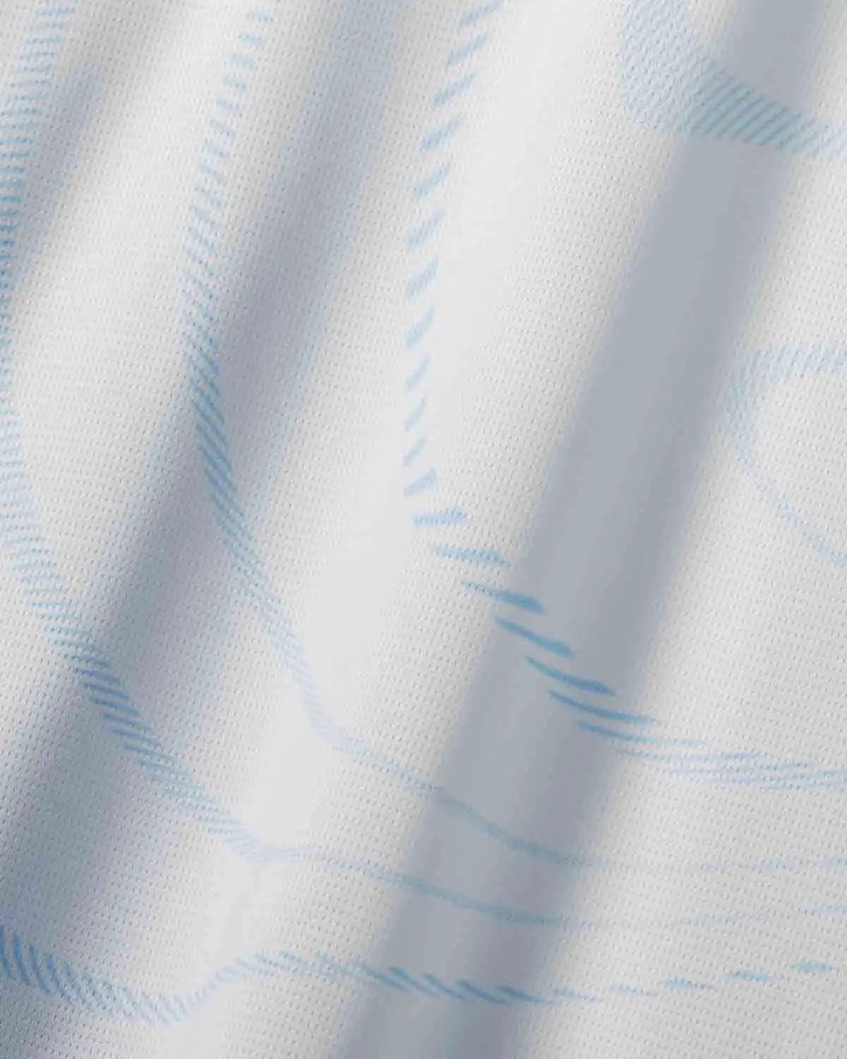 YCrVb4kMdThYy6a | UAE SPORT STORE Close-up of white fabric with pale blue plaid lines and soft folds, showing the textile texture and stitching.
