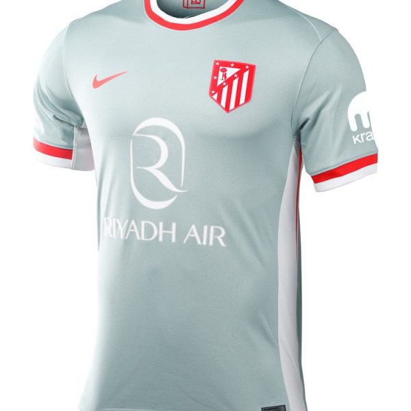 Light blue-gray soccer jersey with red-and-white collar, Atlético Madrid crest on the chest and Riyadh Air sponsor logo on front.