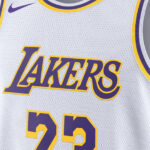 Close-up of a white Los Angeles Lakers jersey with purple and gold trim, Lakers logo, and the number 23.