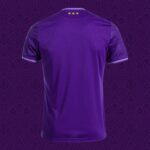 Back view of a purple polo shirt with three gold stars near the collar against a purple decorative background.