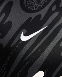 ZwpjwjB1B6bxVOb_b5e9489c-8961-4b28-b33e-31c64789ed64 | UAE SPORT STORE Close-up of dark fabric with a white Nike swoosh logo on a striped pattern