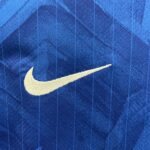 Close-up of a white Nike swoosh logo on blue denim fabric.