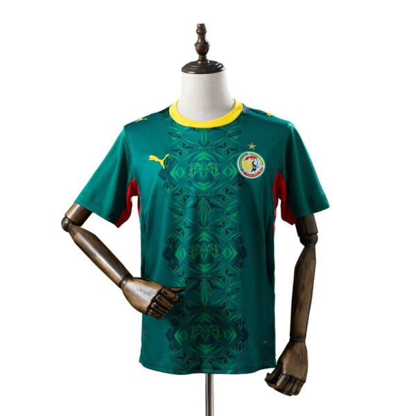 Green soccer jersey with yellow neckline, geometric pattern, Puma logo on the right, circular team crest on the left.