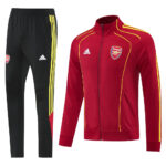 Arsenal red training jacket with yellow piping and crest, paired with black pants with yellow stripes.