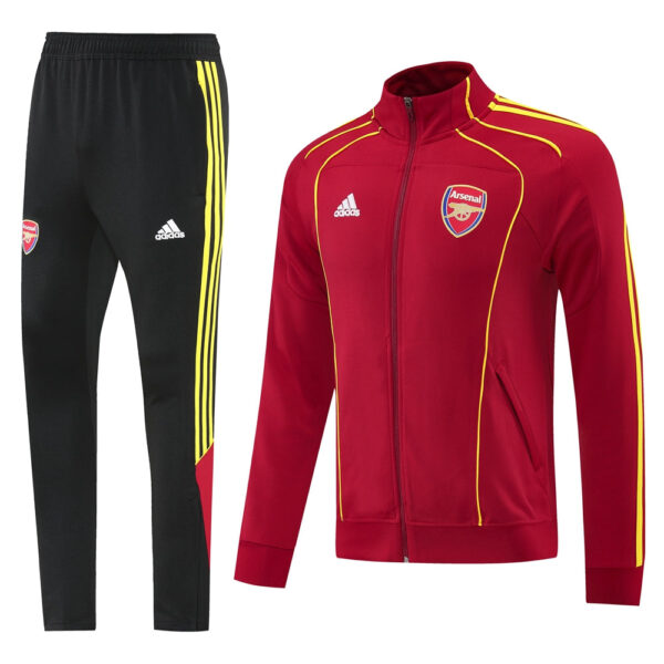 Arsenal red training jacket with yellow piping and crest, paired with black pants with yellow stripes.