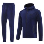 Navy blue Nike jogger pants and matching zip-up jacket shown side by side in a sporty tracksuit set, with Nike logos visible on both pieces.