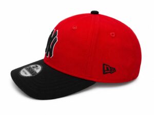 Red baseball cap with a black brim featuring a raised black-and-white NY logo on the front and a small New Era logo on the side.