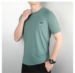 a3753be5 | UAE SPORT STORE Man wearing a teal Nike short-sleeve athletic T-shirt with a small swoosh logo on the left chest, standing with one hand at the collar