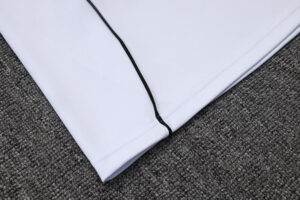 Close-up of pale lavender fabric with a black zipper seam along the edge on a gray carpeted surface