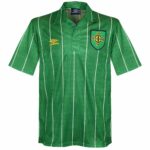 Green polo shirt with white vertical stripes and a crest badge on the left chest.