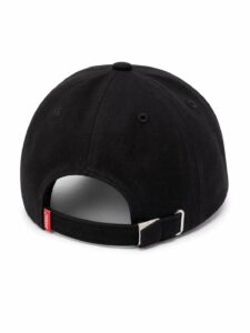 Black baseball cap from the back with an adjustable strap and metal buckle on a white background, tag visible on the strap end
