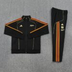 Black Adidas Arsenal tracksuit set: zip-up jacket with orange stripes on sleeves and chest, matching pants with orange stripes and team crest.