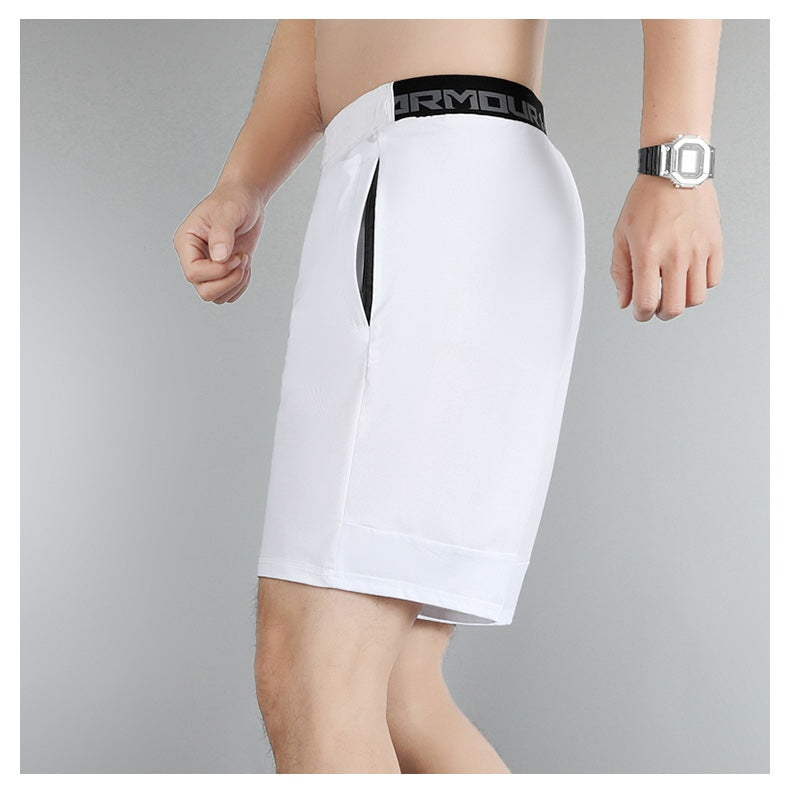 a6c96f29 | UAE SPORT STORE Male model wearing white athletic shorts with a black elastic waistband (Under Armour) and a side pocket visible on the left hip, knee-length cuffed hem.