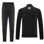 Black athletic tracksuit: pants with subtle gold/yellow side panels and a matching long-sleeve zip-free jacket with a small NTS label on the back neck.