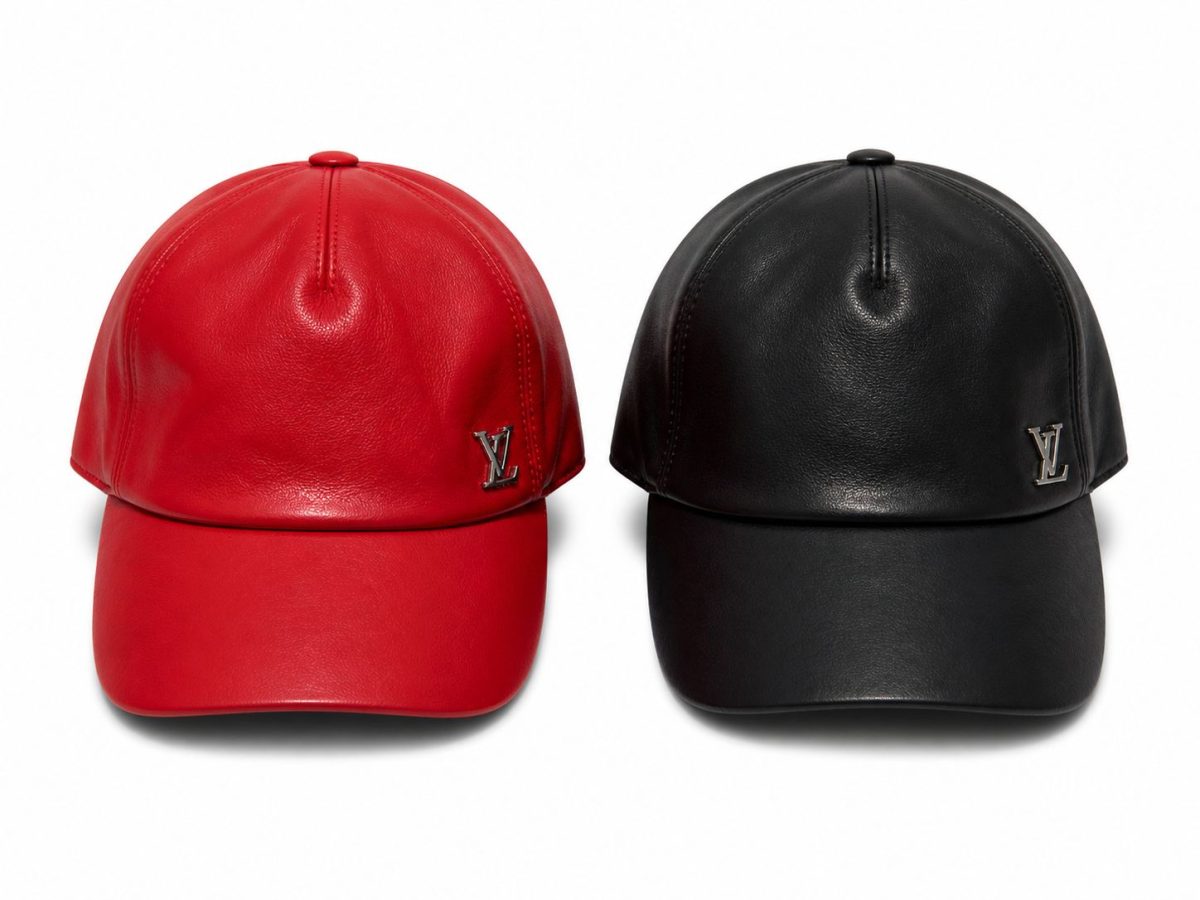 Two leather baseball caps, one red and one black, with silver LV logos on the front panels.