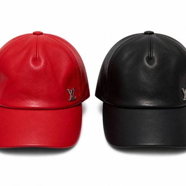 Two leather baseball caps, one red and one black, with silver LV logos on the front panels.