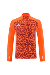 Orange leopard-pattern long-sleeve athletic top with half-zip collar and white Adidas logo on the chest.