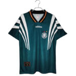 Teal Adidas soccer jersey on a hanger with white sleeve stripes, a club crest on the left chest, and the Adidas logo centered on the chest.