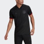 Men's black Adidas Germany national team soccer jersey with crest and four stars, red sleeve cuffs, worn by a model.