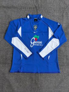 Blue Brazilian national team long-sleeve training jersey with white panels and Guaraná Antarctica sponsor logo on the chest, Nike emblem above, laid flat on a gray surface.