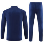 Navy blue athletic tracksuit: long-sleeve top and tapered pants, shown from the back of the top and front of the pants side view.