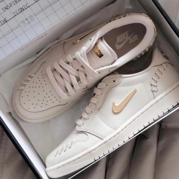 White Nike Air sneakers with a gold swoosh inside a shoebox.