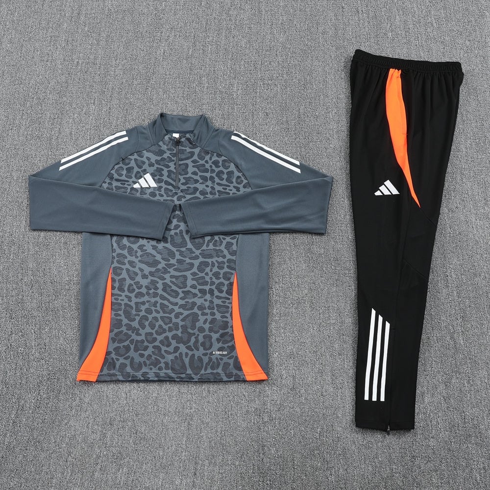 a9f0c552 | UAE SPORT STORE Adidas track suit laid flat: gray leopard-print long-sleeve top with orange side panels and matching black pants with orange accents.