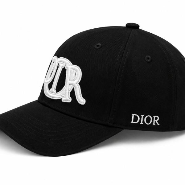Black Dior cap with large white 'OUR' embroidery on the front and 'DIOR' on the side.