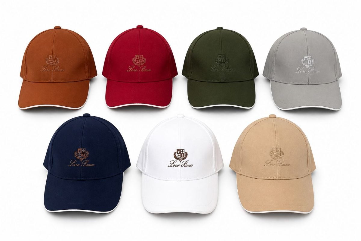 Seven baseball caps in orange, red, olive, gray, navy, white, and tan with an embroidered crest and 'Loro Piana' text visible on each cap.
