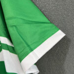 Close-up of bright green fabric with white folded trim, showing stitching and texture detail (likely sports jersey material).