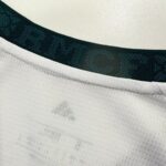 acae503a-5d35-4731-835e-07667f74d51b | UAE SPORT STORE Close-up of a white collared shirt with a dark green ribbed neckline and visible gray sweat stains near the seam.