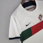 White jacket on a wooden hanger featuring a crest badge and a red-green flag graphic visibility on the front.