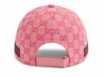 Pink Gucci baseball cap, back view, with GG logo pattern and pink leather strap with a gold buckle, accented by green and red stripe on the side