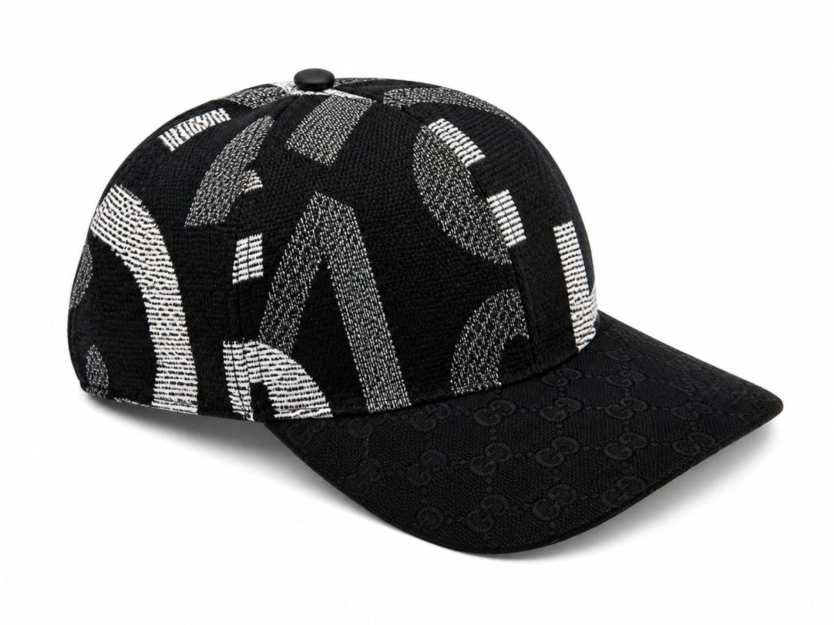 Black baseball cap with a textured black crown sporting white geometric patterns and a brim covered in a repeating Gucci monogram pattern.