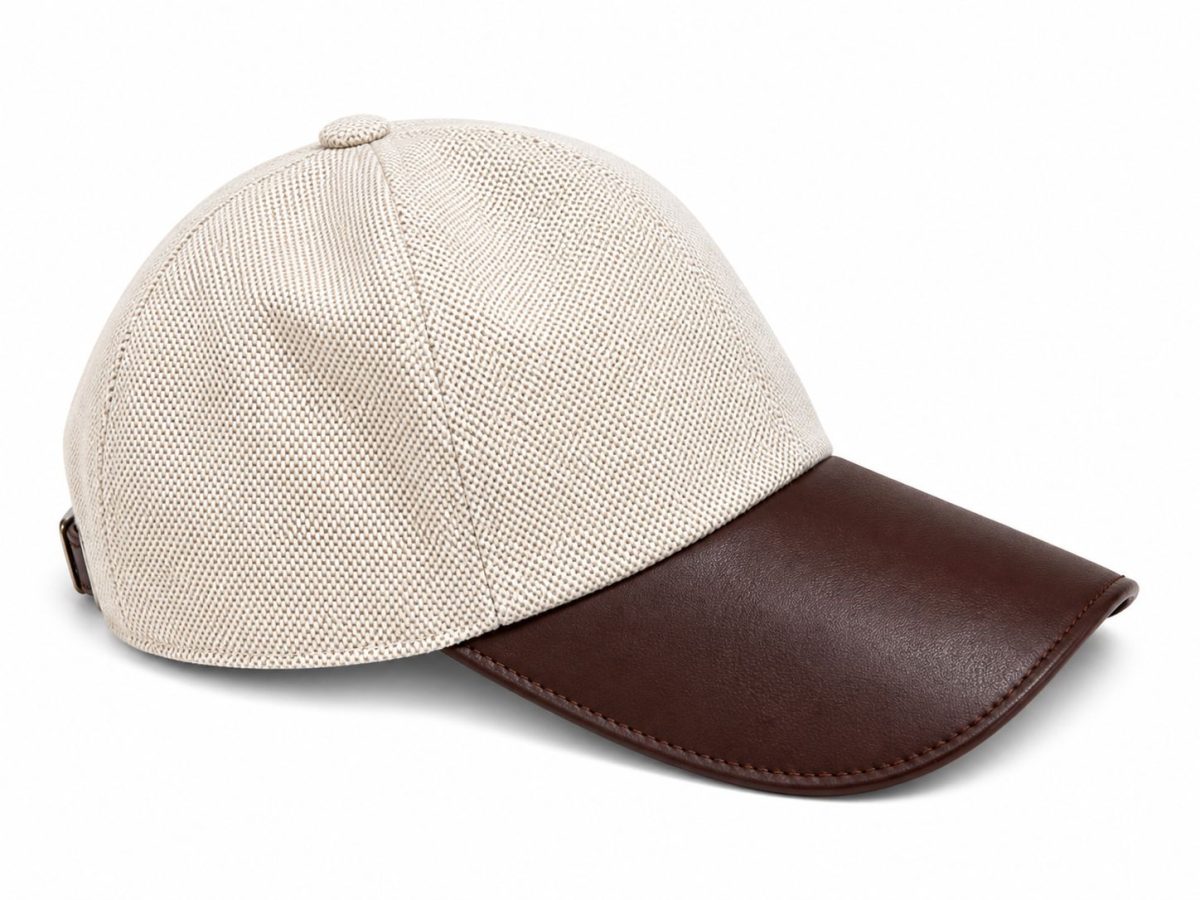 Beige textured cap with a brown leather curved brim and top button.