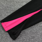 Black athletic leggings with a bright pink inner panel and ankle zipper showing a side zipper detail.