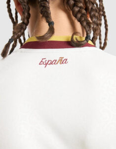 Back view of a person with braided hair wearing a white shirt featuring the word 'España' on the back.