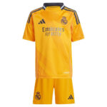Real Madrid yellow away jersey and shorts with club crest and Emirates Fly Better sponsor on white background.