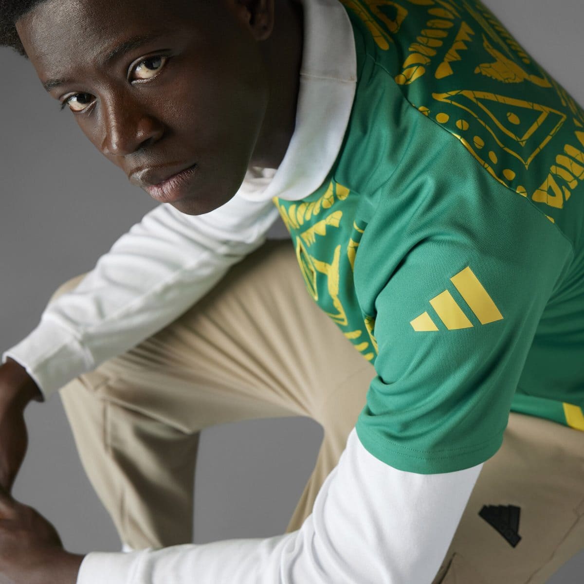 Close-up of a person wearing a green sports jersey with yellow designs, looking toward the camera.