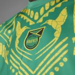 Close-up of the Jamaica Football Federation crest on a green jersey with yellow patterning.