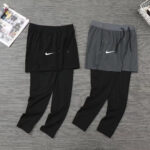 Two outfits of layered athletic pants and shorts: black shorts over black pants on the left, gray shorts over black pants on the right, both with white Nike swoosh logos.