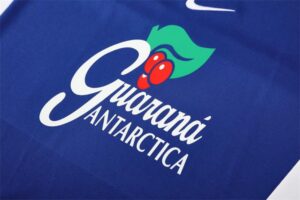 Brand logo on a blue surface with a green leaf, red berries, and the stylized text 'Guardia Antarttica' or similar.