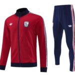 Red Arsenal track jacket with navy collar and crest, beside navy track pants with red/white stripes.