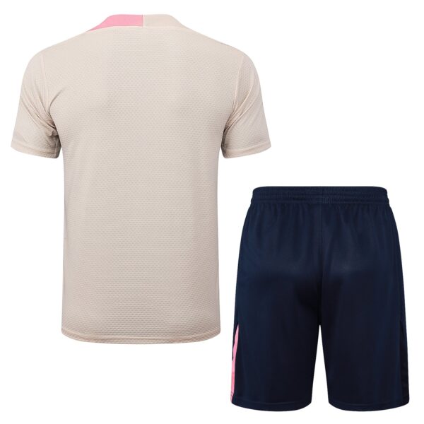 Beige mesh-textured short-sleeve shirt paired with navy shorts that have a pink side stripe, shown from the back.