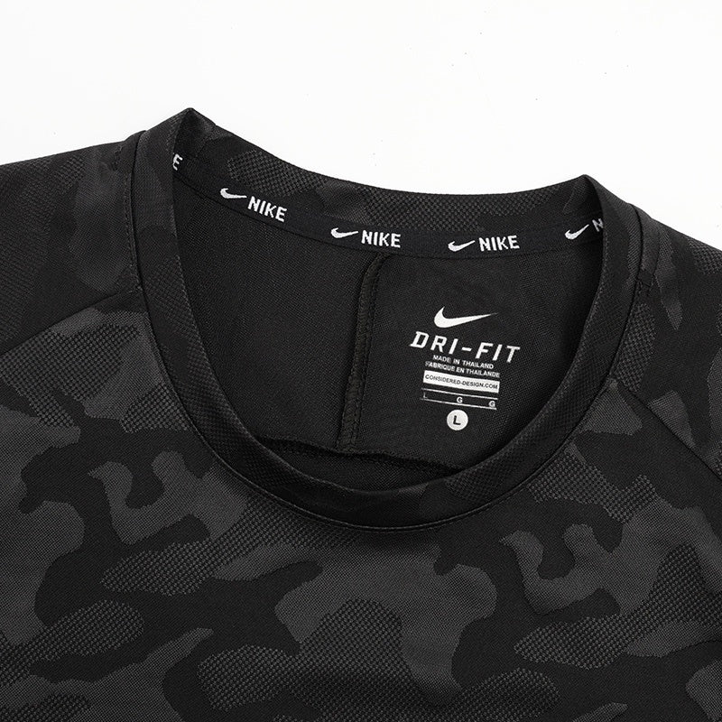b029d709 | UAE SPORT STORE Close-up of a black camo Nike Dri-Fit athletic shirt neck area, showing the Nike logo on the collar and size tag inside.