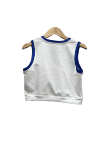 Back view of a white sleeveless shirt with blue trim on the neck and armholes, hanging on a wooden hanger.