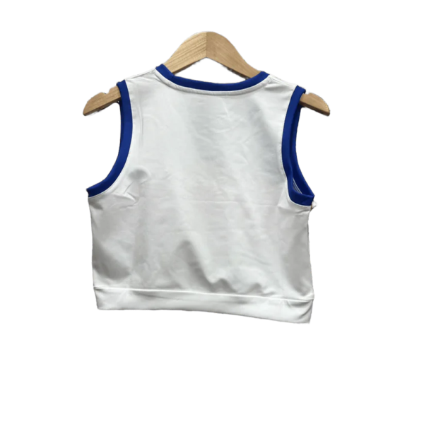 Back view of a white sleeveless shirt with blue trim on the neck and armholes, hanging on a wooden hanger.